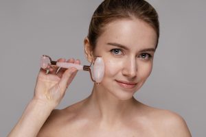 a woman using jade roller as an anti-aging treatment