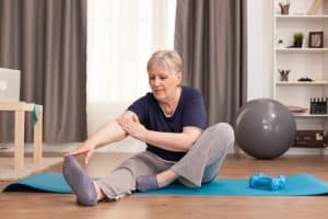 Measuring Your Fitness Level after 50- The Ultimate Guide 7 active old woman exercising yoga mat her comfortable apartment